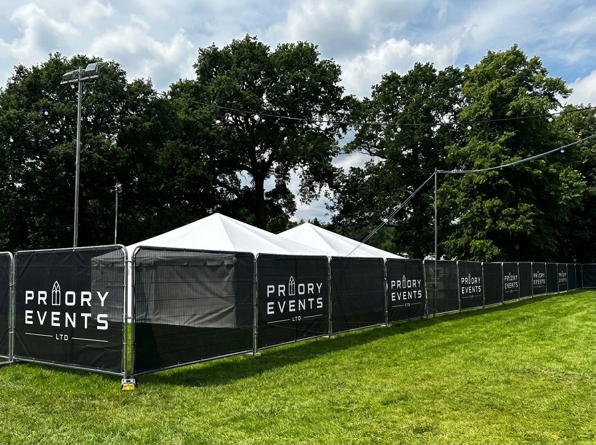 Priory Events branded Heras security fencing around a marquee at an outdoor event