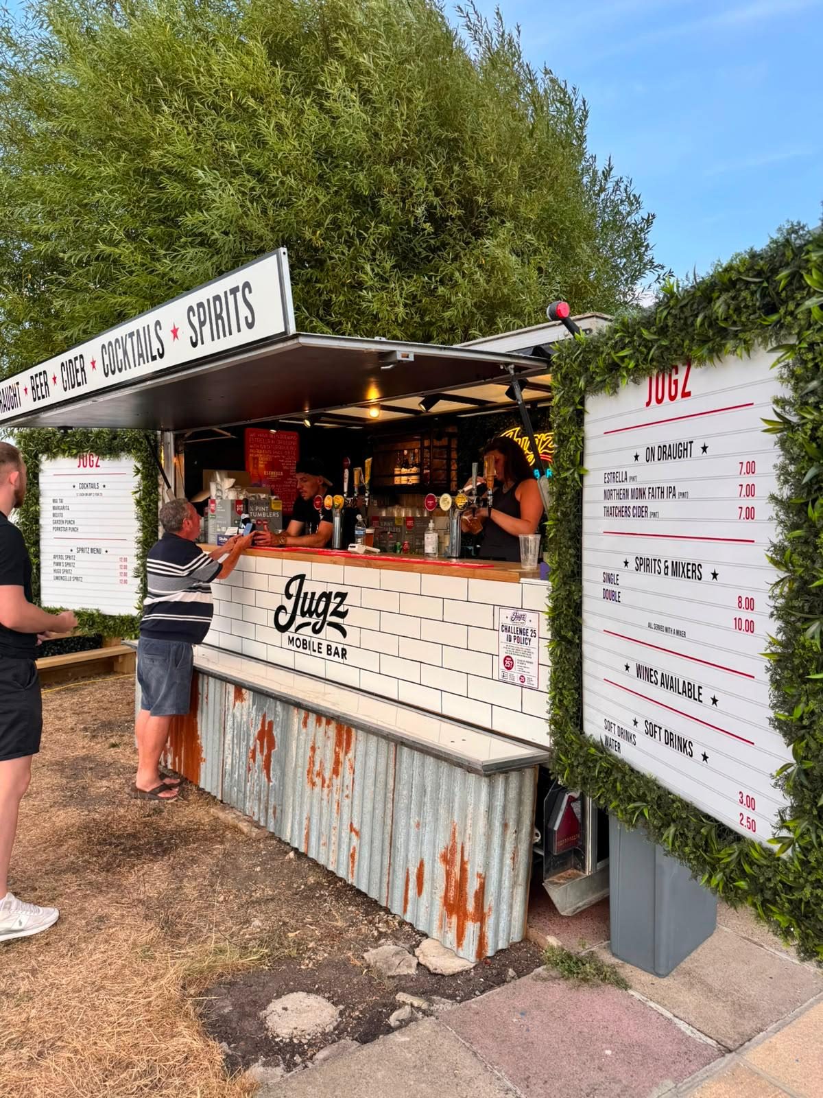 Jugz Mobile Bar unit set up outdoors with menu boards and draught taps
