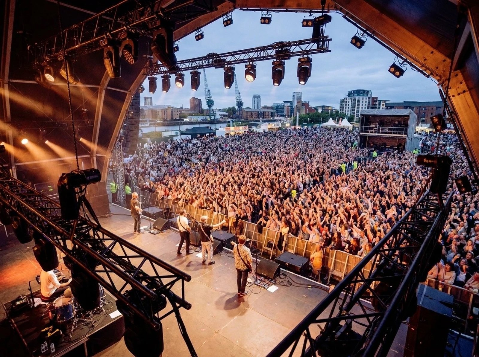 View from the wings of a band playing to a large festival crowd