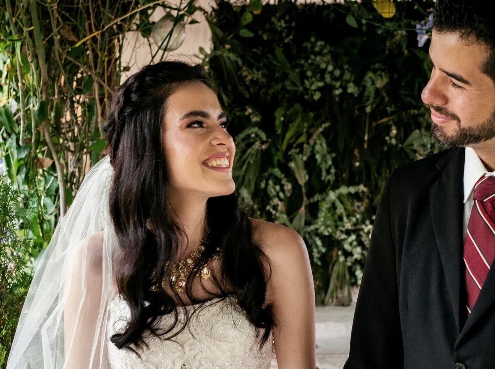 Bride and groom smiling at each other during their wedding ceremony